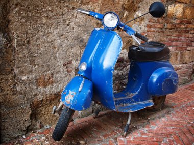 Vintage scooter in front of a brick wall clipart