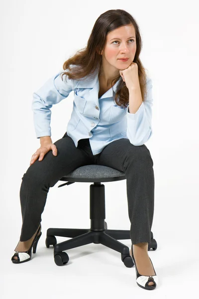 Flicka i kostym på en stol — Stockfoto