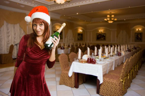 Girl in a Christmas hat with champagne — Stock Photo, Image