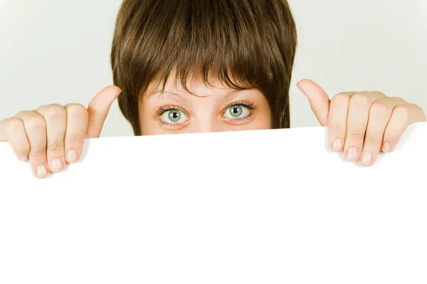 Girl hiding behind a white banner — Stock Photo, Image