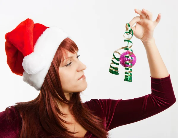 Girl in a Christmas hat with a decoration — Stock Photo, Image