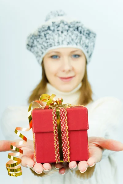Girl in winter hat gives gift box — Stock Photo, Image