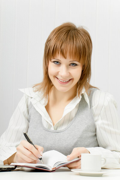Smiling attractive girl with a notebook. Office worker