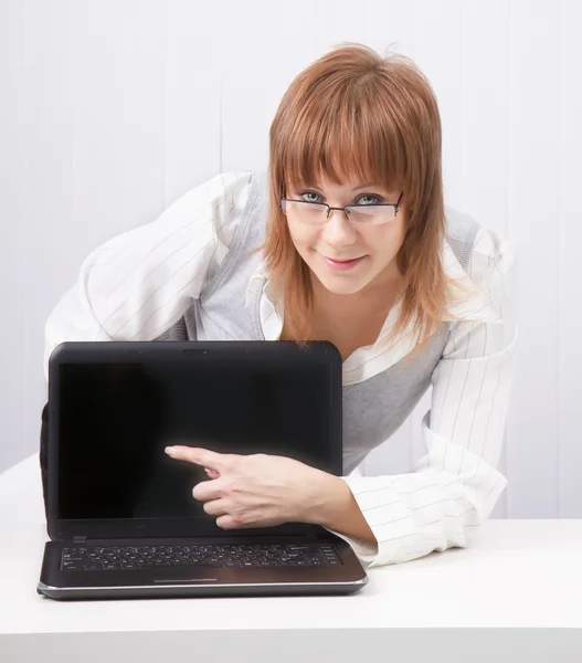 Girl shows a finger on a laptop — Stock Photo, Image