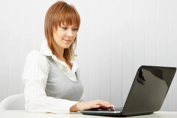 Menina feliz sorrindo atraente com um laptop — Fotografia de Stock