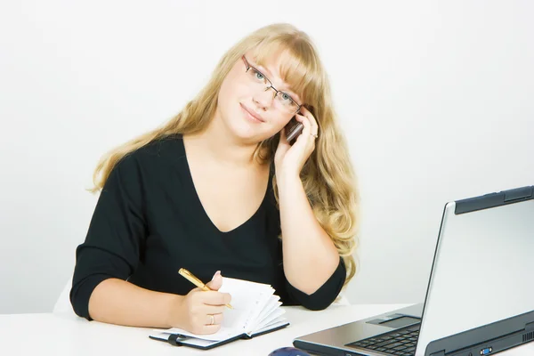 Trabajador de oficina. Chica rubia con portátil hablando en un teléfono celular —  Fotos de Stock