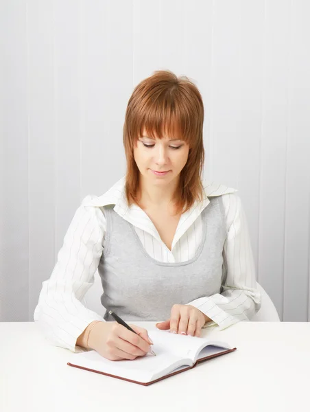 Business attraktiva flicka med en anteckningsbok och penna. — Stockfoto