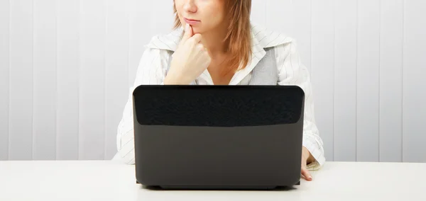 Eftertänksam kvinna med en bärbar dator — Stockfoto
