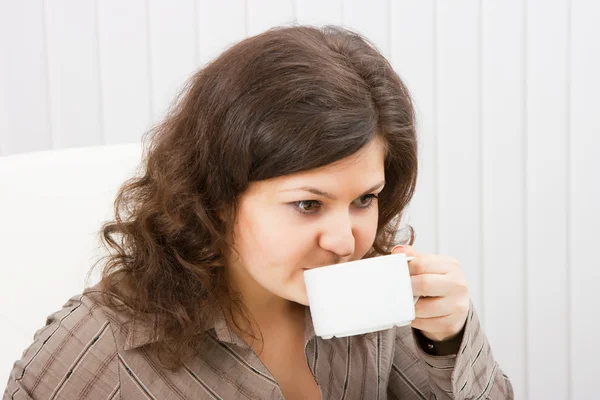 Брюнетка пьет кофе из чашки. — стоковое фото