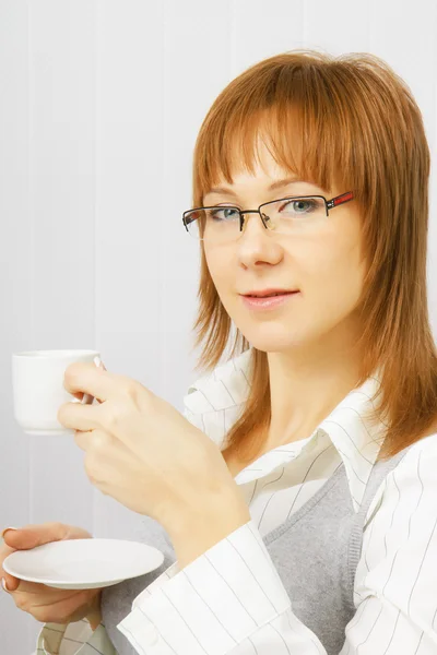 Ελκυστικό κορίτσι στο γραφείο με ένα φλιτζάνι καφέ — Φωτογραφία Αρχείου