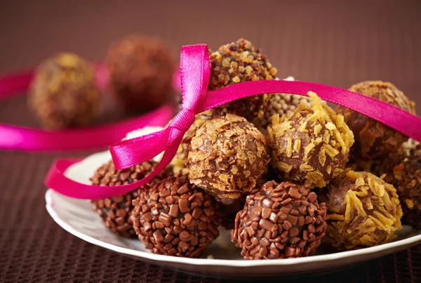 Chocolate truffles and pink ribbon — Stock Photo, Image