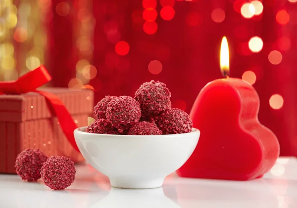 Raspberry truffles and burning candle — Stock Photo, Image
