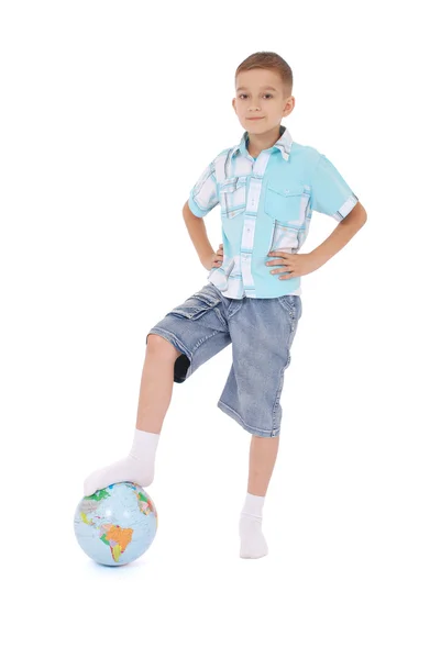 Der Junge hat einen Fuß auf den Globus gesetzt — Stockfoto