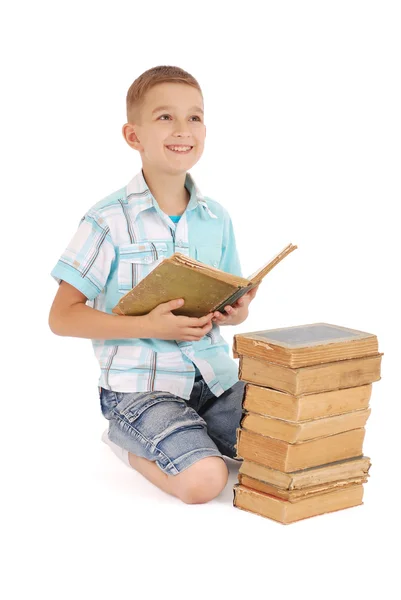 Jonge jongen dromen in de buurt van de oude open boek — Stockfoto