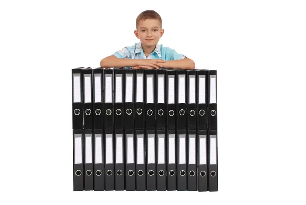 The boy bases on many big black folders — Stock Photo, Image