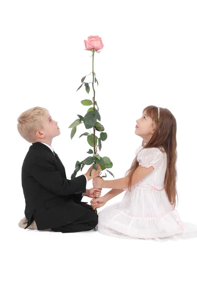 The boy and the girl look at a rose — Stock Photo, Image