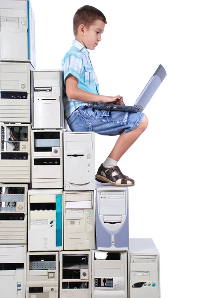Chłopiec bawi się laptopa kroków od starych komputerów — Zdjęcie stockowe