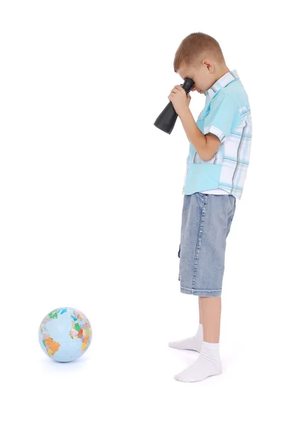 The boy looks through the field-glass at the globe — Stock Photo, Image