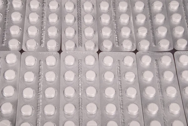 Massor av vita tabletter i förpackning — Stockfoto