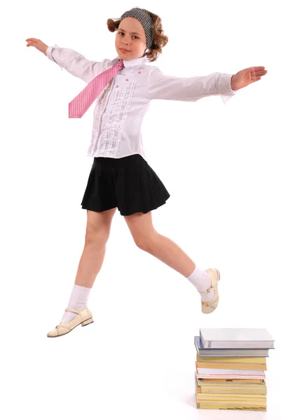 Девушка прыгает из кучи книг — стоковое фото