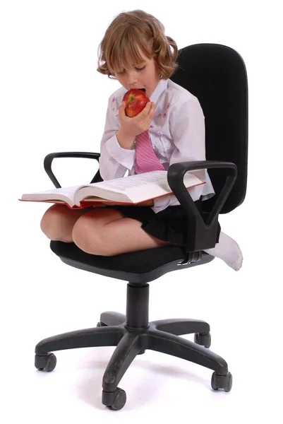 Kız bir sandalyede oturan bir elma yiyor. — Stok fotoğraf
