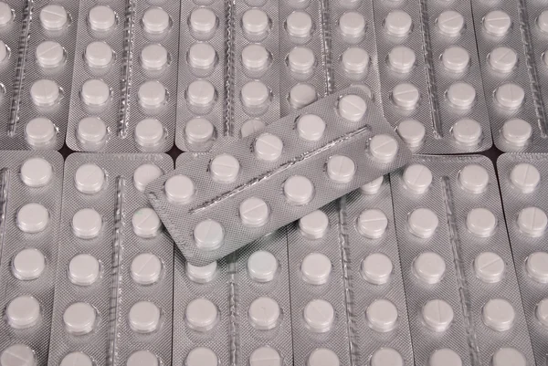 Rengeteg fehér tabletta csomagolásban — Stock Fotó