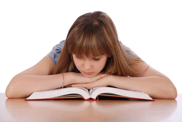 Mädchen sitzt an einem Tisch und liest das Buch — Stockfoto