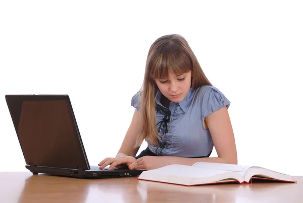 Menina olha o livro salpicado coloca laptop — Fotografia de Stock
