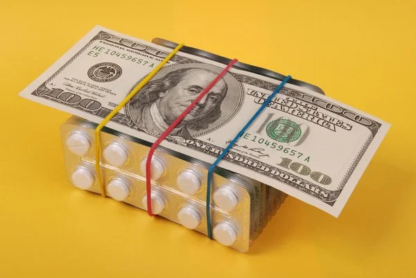 Sto dolarů si klade na balení bílé tablety — Stock fotografie