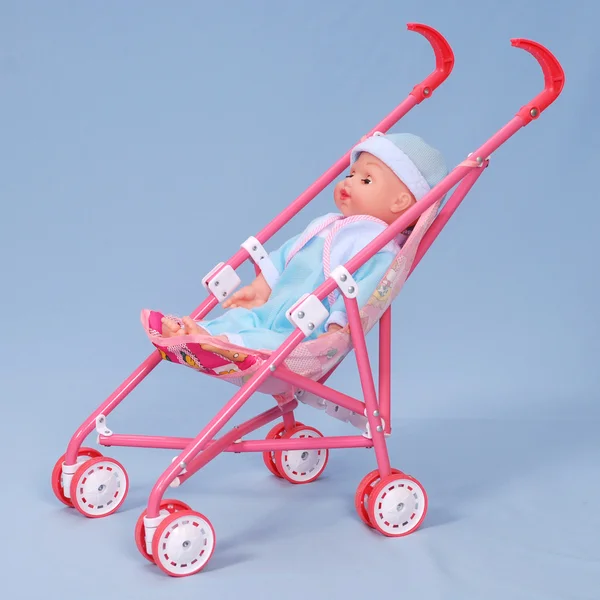 stock image Toy baby buggy on blue background.