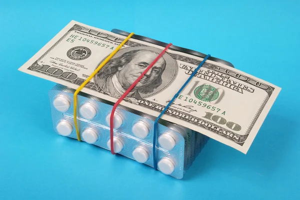 Сто долларов лежали на упаковке белых таблеток — стоковое фото