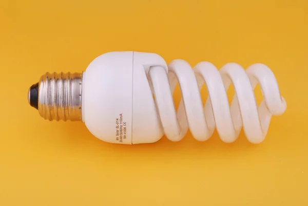 Compact Fluorescent Light Bulb Yellow Backlground — Stock Photo, Image