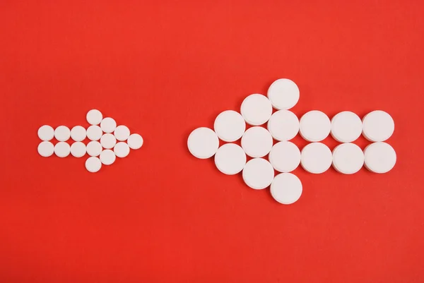 Dwie strzałki zebrane tabletek są skierowane przeciwko sobie nawzajem — Zdjęcie stockowe