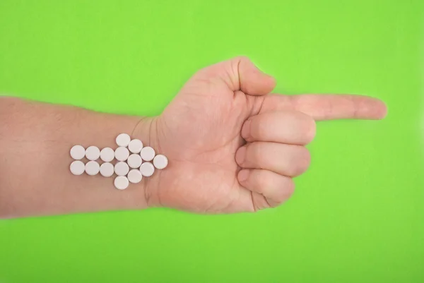白い錠剤から矢印が組み合わされています 矢印は 一方を産みます 緑の背景に — ストック写真