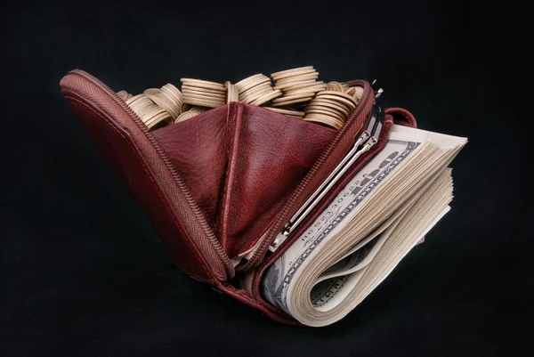 Кожаный кошелек, набитый монетами и бумагой — стоковое фото