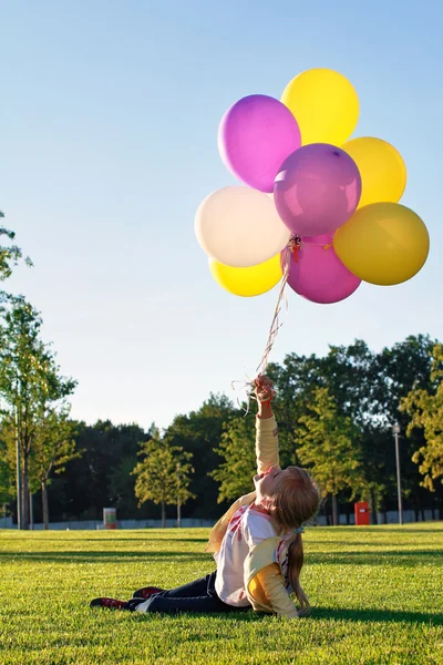 Kind mit bunten Luftballons — Stockfoto
