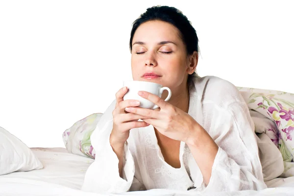 一个年轻女人做梦和控股白色一杯咖啡在卧室的床上 剪切路径 — 图库照片