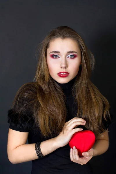 Young woman holding a red heart — Stock Photo, Image