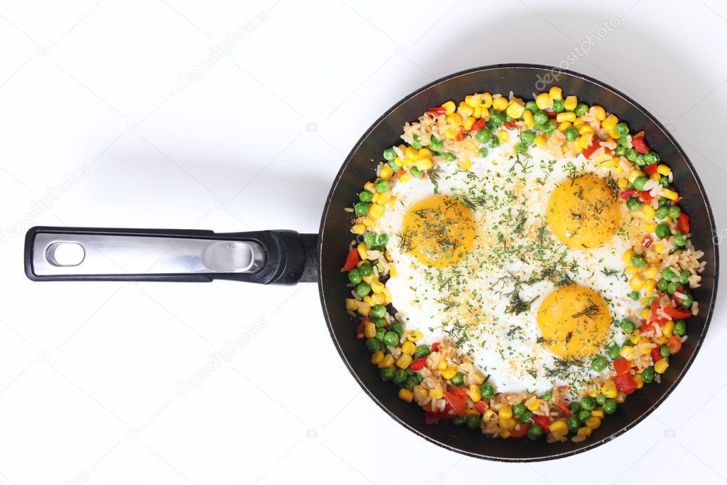 Eggs and vegetables in a frying pan isolated on white