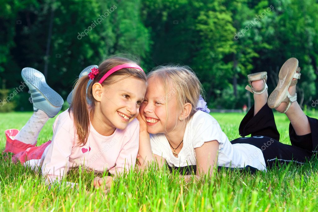 Two cute girls laughing on the grass — Stock Photo © Shvydkova #4876676