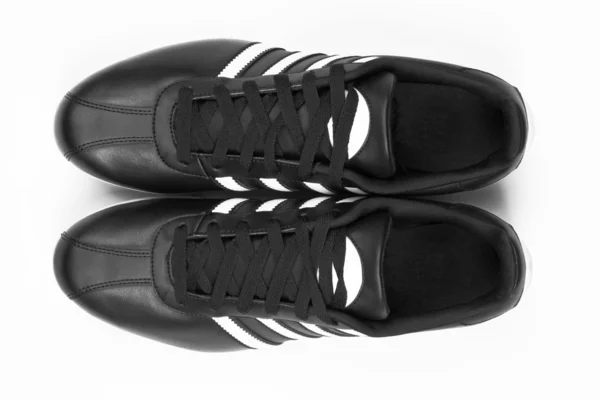 Чорні кросівки з білими смужками — стокове фото