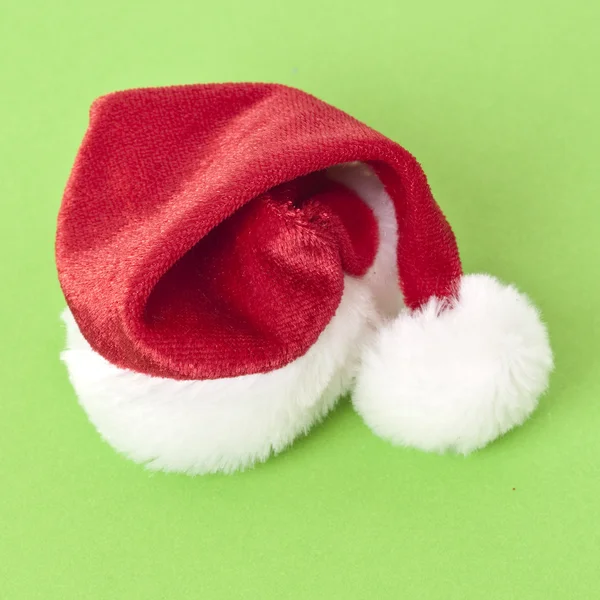 Kerstman hoed op een levendige groene achtergrond — Stockfoto