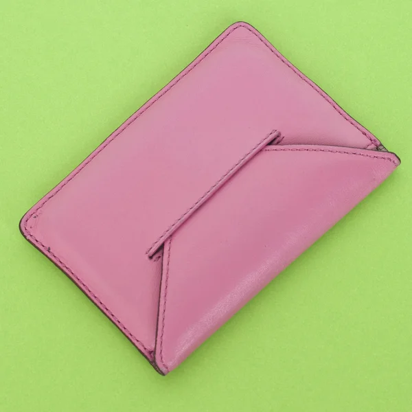 Różowy portfel na wibrujący zielony — Zdjęcie stockowe