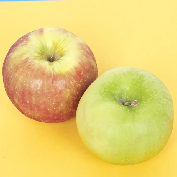 Paar Äpfel auf leuchtendem Gelb — Stockfoto