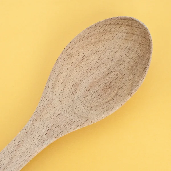 Cucchiaio di legno su giallo vibrante — Foto Stock