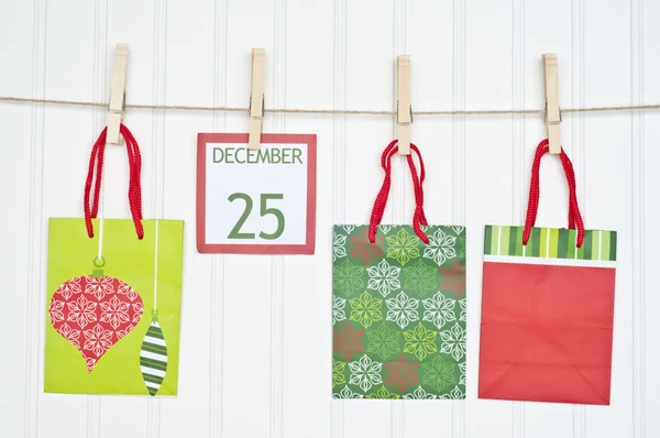 Presente saco e calendário de Natal página em um varal — Fotografia de Stock