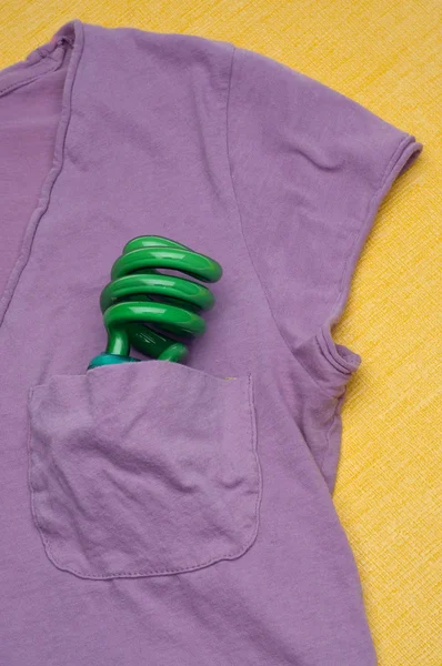 Zöld kompakt fluoreszkáló villanykörte-ban egy ing zseb — Stock Fotó