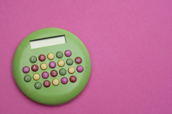 充满活力的粉红色背景上的独特绿色 Brigth 计算器 — 图库照片