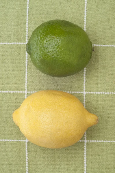 Cytryny i limonki na ręcznik kuchenny zielony — Zdjęcie stockowe