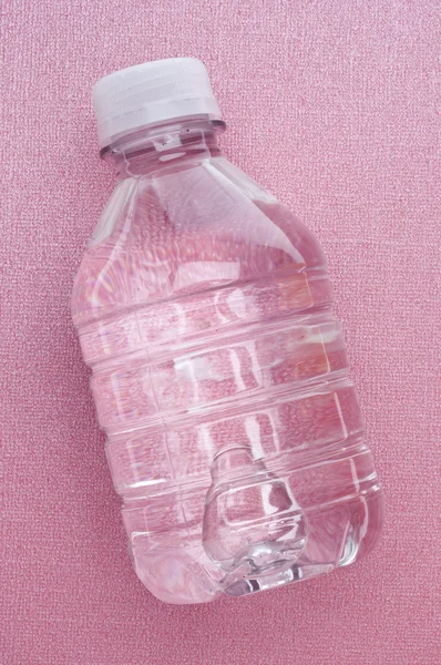 ピンクの背景に新鮮なきれいなボトル入りの水 — ストック写真